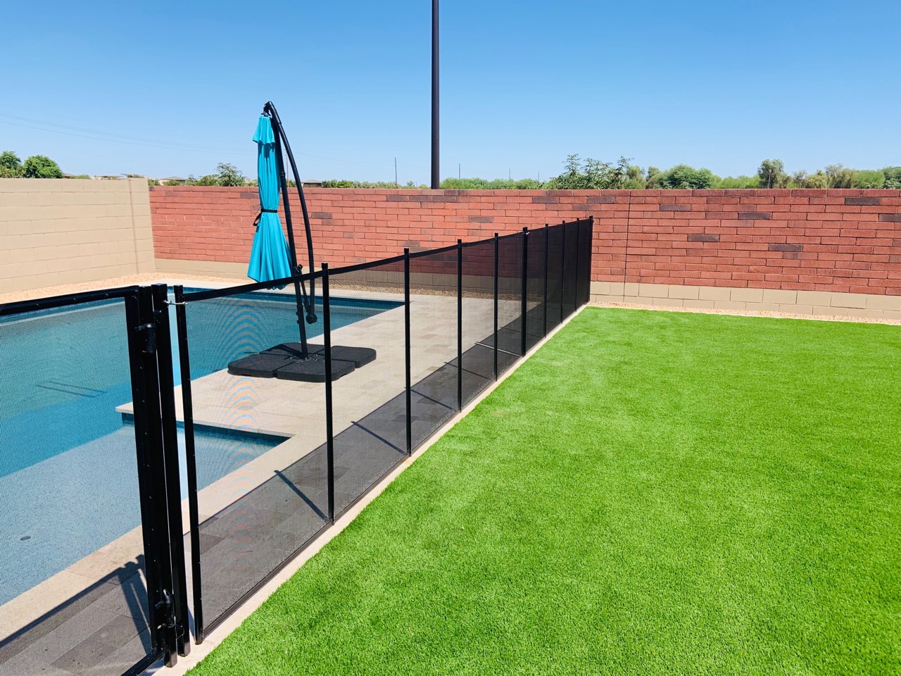 mesh pool fence straight barrier attached to brick wall