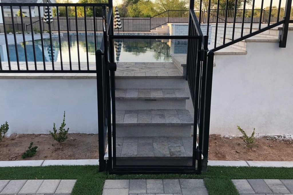Self-closing mesh pool safety gate at the top of pool steps