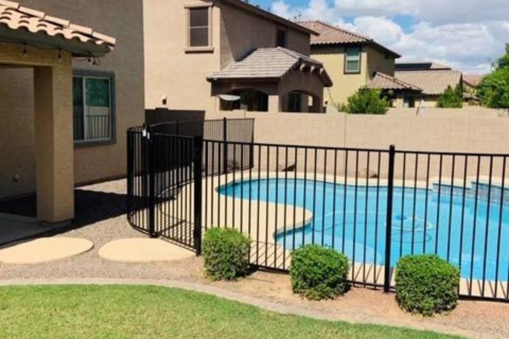 Black iron fence separating a Phoenix home and patio from the swimming pool