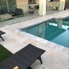 glass fence installed on pool deck pavers