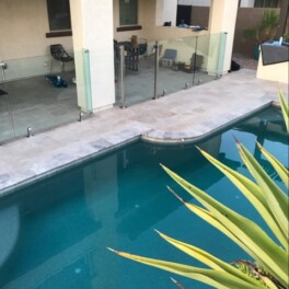 glass pool fence installed on paver deck tiles
